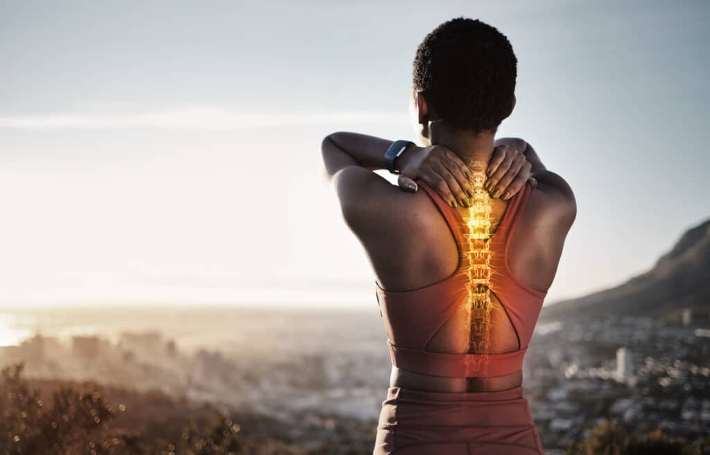Person holding their neck with an illustrated spine overlay showing upper back and cervical pain.