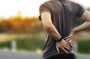 a man has back pain in the sunset time