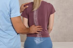 Doctor examining of a patients back with a focus on the lumbar region.